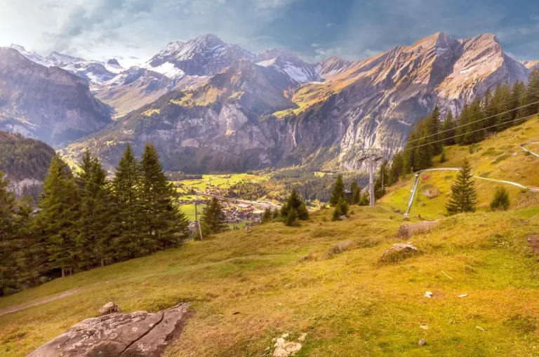 Prado y bosque de abetos frente a las montañas que rodean Kandersteg, en Suiza
