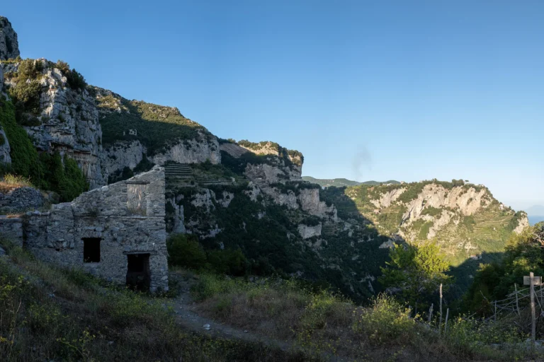 El Sentiero degli Dei entre los acantilados, con una casa en ruinas junto al camino