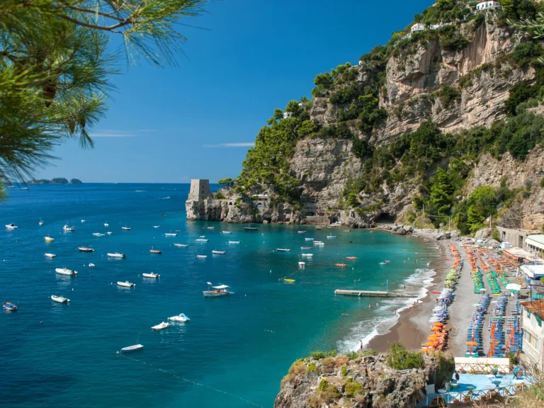 Playa de Fornillo, en Positano, con su torre y las barcas fondeadas