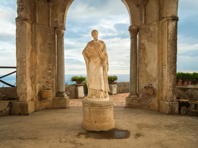 Templete con una estatua en los jardines de Villa Cimbrone, con el mar al fondo