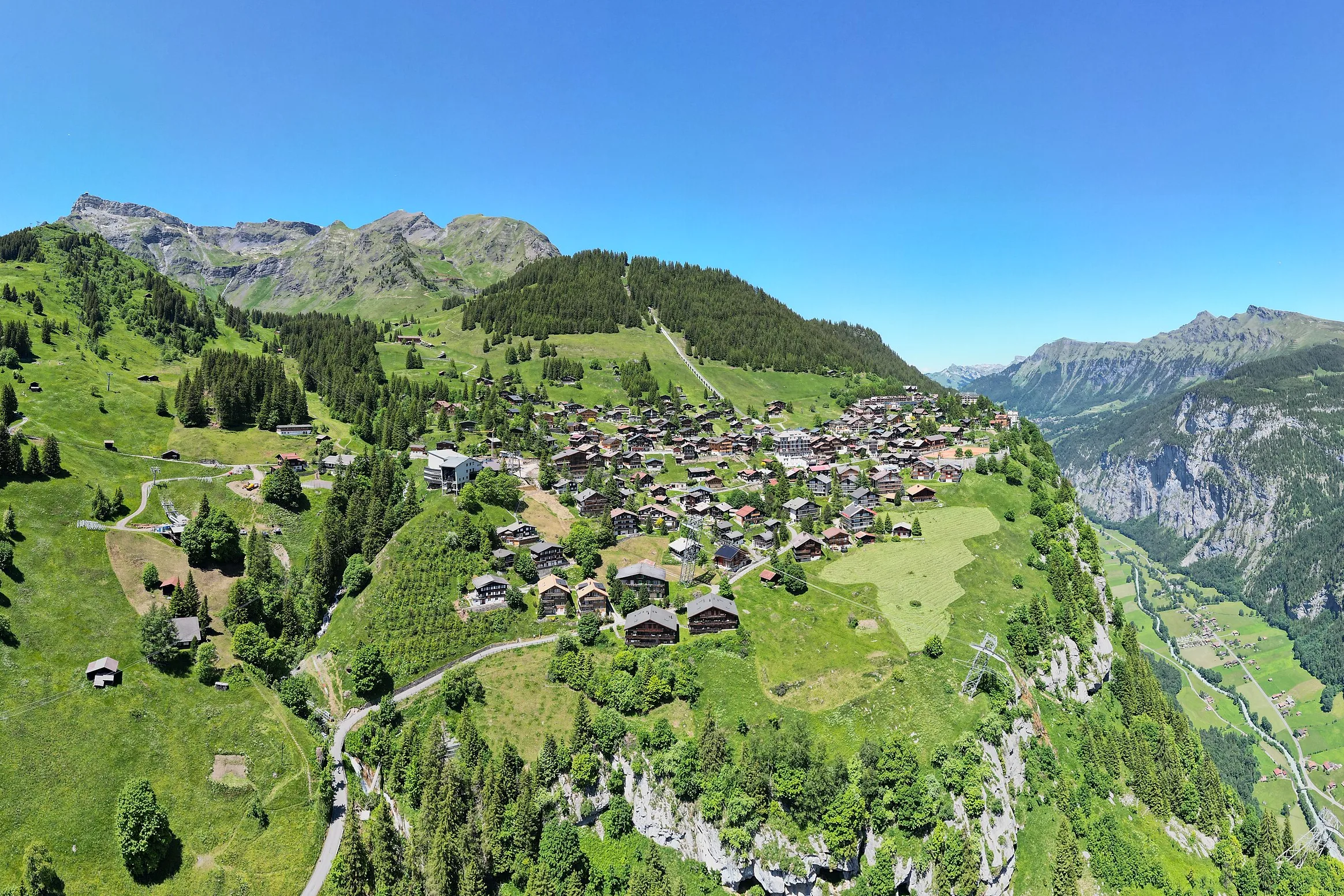 Mürren en su terraza verde sobre el valle de Lauterbrunnen, con las paredes de roca y las cumbres al fondo