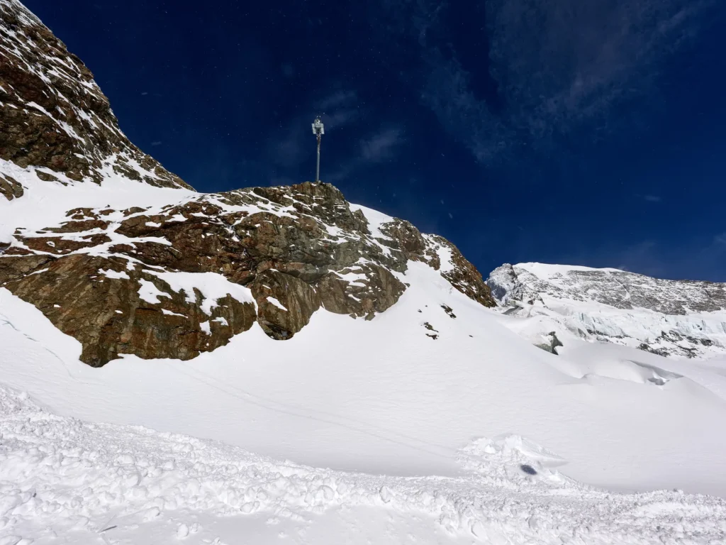 La cresta rocosa del Jungfraujoch con nieve y el glaciar detrás