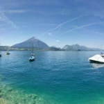 El lago de Thun, de agua turquesa, con barcas y el Niesen al fondo