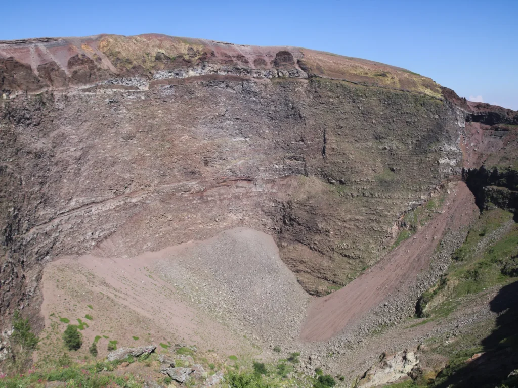 Interior del cráter del Vesubio, con sus paredes de roca y la ladera de ceniza