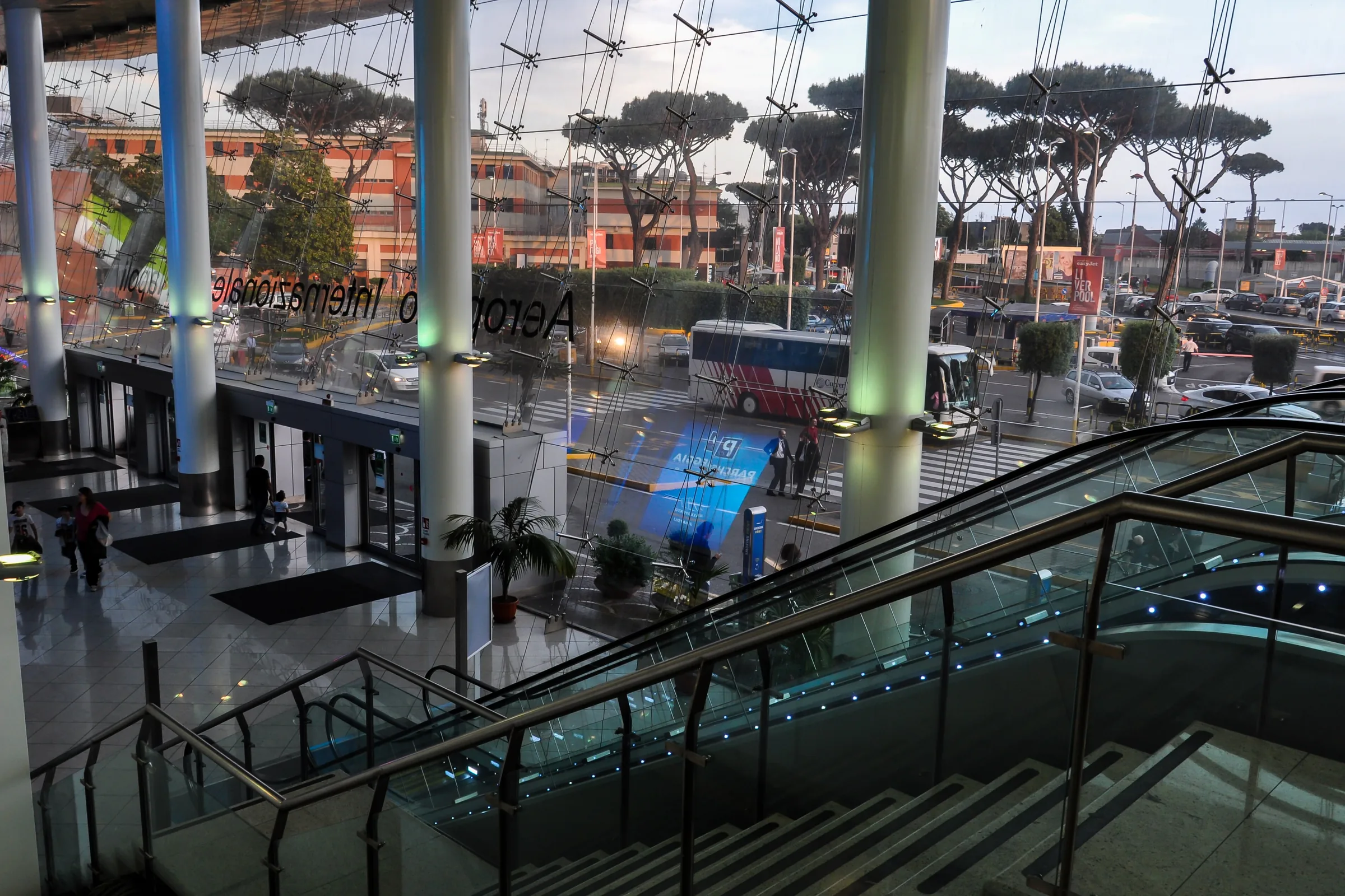 Vestíbulo de la terminal del aeropuerto de Nápoles, con la salida y los autobuses al fondo