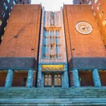 Fachada de ladrillo del Ayuntamiento de Oslo, con su reloj y la escalinata de entrada