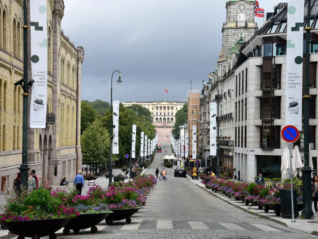 Karl Johans gate con jardineras de flores y el Palacio Real al fondo
