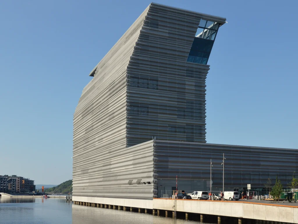 El edificio del museo MUNCH, con la parte alta inclinada, junto al agua en Bjørvika
