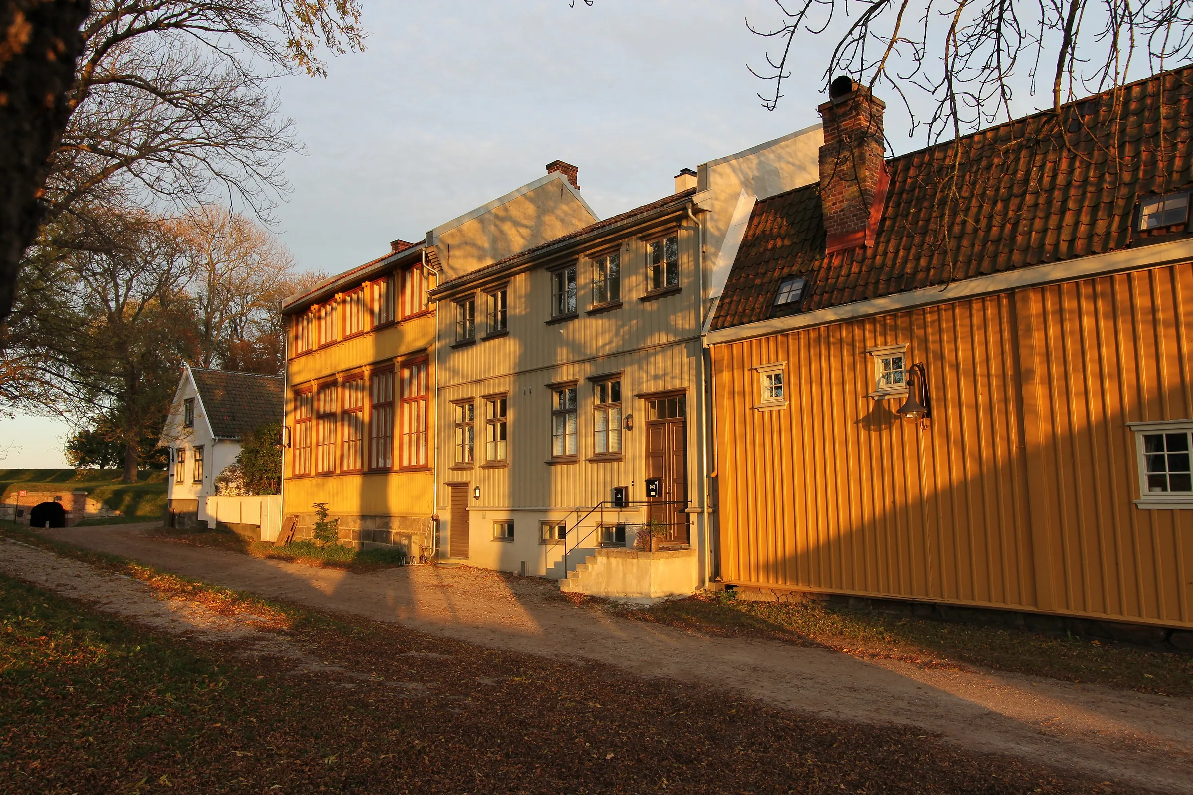 Casas de madera amarillas y blancas del casco antiguo de Fredrikstad con luz de tarde